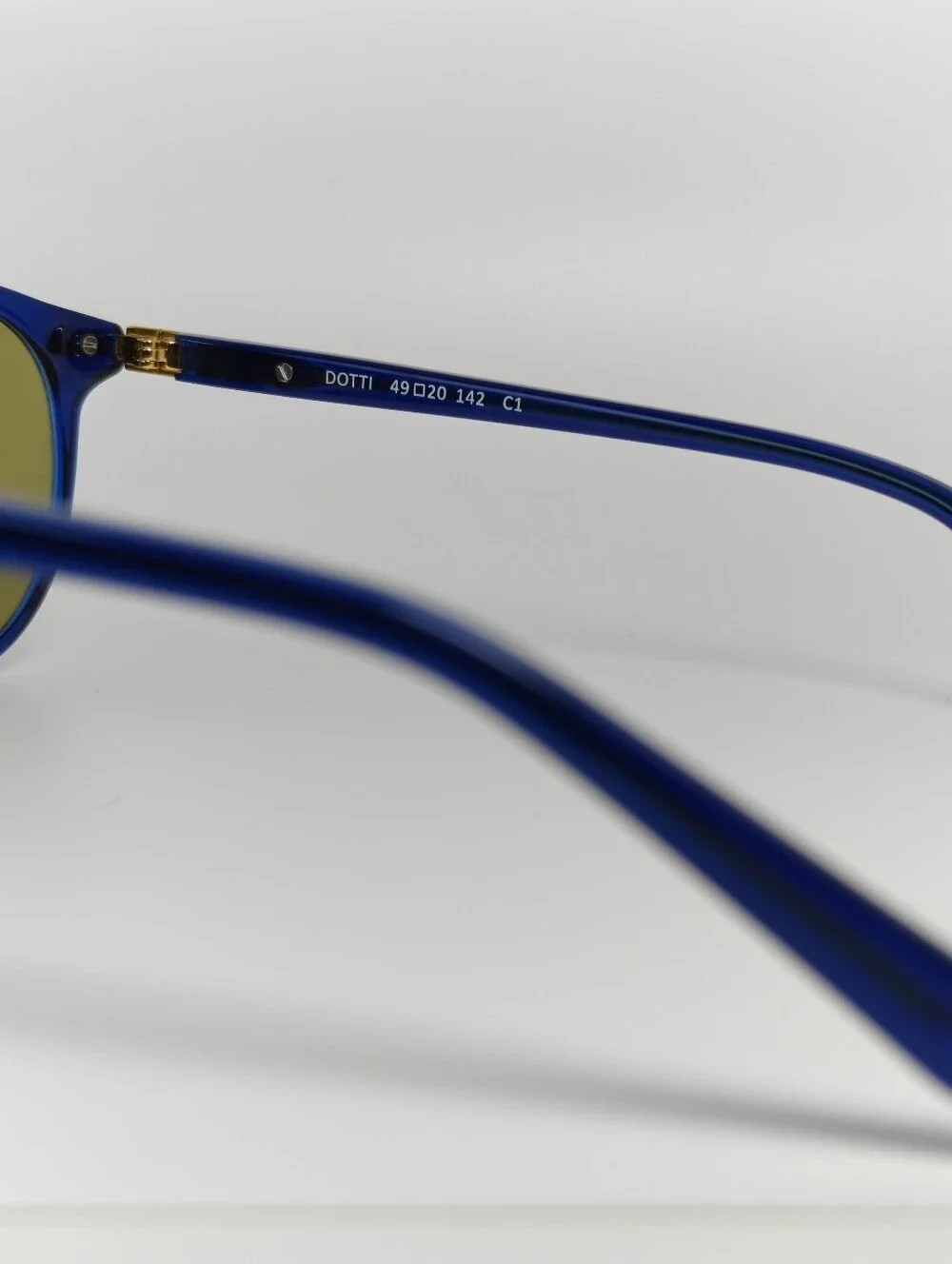 Dotti. Round Navy Translucent frame. Gold Hinge Extends to frame front.